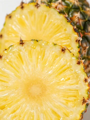 Ananas fresco affettato su tavolo di legno rustico