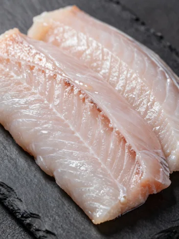 Filetti di anguilla fresca con spezie su tagliere di legno