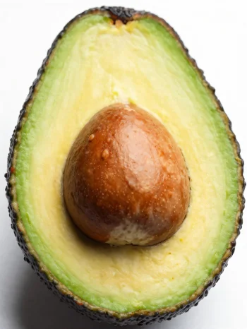 Avocado fresco tagliato con interno verde cremoso su superficie di legno