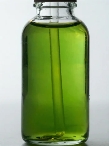 Olio di avocado in bottiglietta e ciotolina su sfondo neutro chiaro
