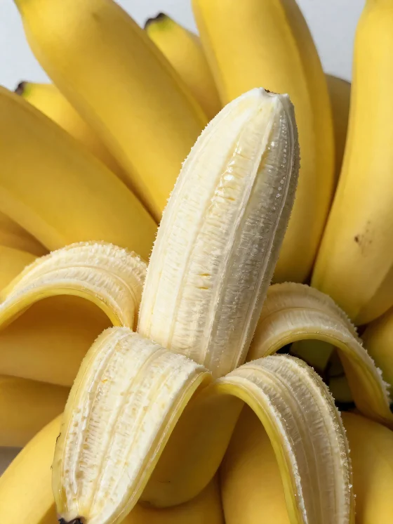 Banana fresca intera e a fette, in ciotola e su tavolo rustico