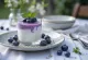 Yogurt probiotico ai mirtilli servito in bicchieri, decorato con mirtilli freschi