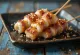 Enoki maki yakitori funghi avvolti nel bacon, serviti con semi di sesamo e cipollotto fresco