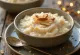 Narkeler payesh pudding di riso al cocco, decorato con scaglie di mandorle e cocco.