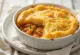 Fish pie all'olio speziato, servito con patate, pezzi di pesce e formaggio
