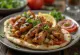Kebab all'aglio servito con pita fresca e succo di limone