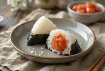Onigiri ripieni di prugna Umeboshi serviti con fogli di nori freschi