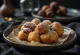 Zeppole servite con crema al cioccolato, bignè dorati con crema al cioccolato sopra