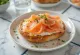 Pretzel servito con salmone affumicato, ricco salmone affumicato sopra, croccante fuori e morbido dentro.