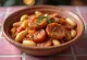 Gigantes Plaki con salsiccia, ricco piatto di fagioli speziati servito