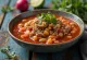 Pozole servito con lime, coriandolo e cipollotto fresco