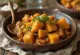 Tajine classico di patate dolci, servito con ricche spezie e coriandolo fresco